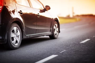 Crédence de cuisine en verre imprimé Voitures rapides asphalt road view with a car in countryside at beautiful sunset