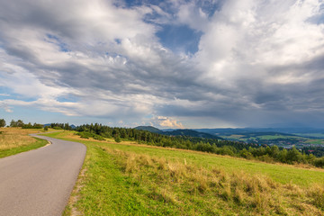 Fototapeta na wymiar Rural scenery. Fields, mountains and clouds on the sky. Pieniny National Park. Malopolska, Poland.
