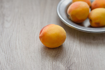 Still life of peaches in a rustic plate on a wooden background