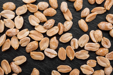 Obraz premium fresh peanuts on a dark stone background