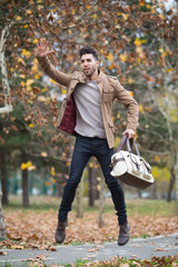 Young adult man handsome jumping in the wood, winter autumn day