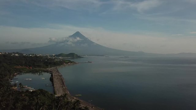 AERIAL SHOT: Pull away shot of Mayon Volcano with the Boulevard below. Puro and Lamba, Legazpi City, Philippines. Views of cocount trees, Mayon Volcano and the sea