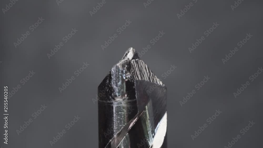 Poster Silver drill bit rotation on a dark background. Macro view.