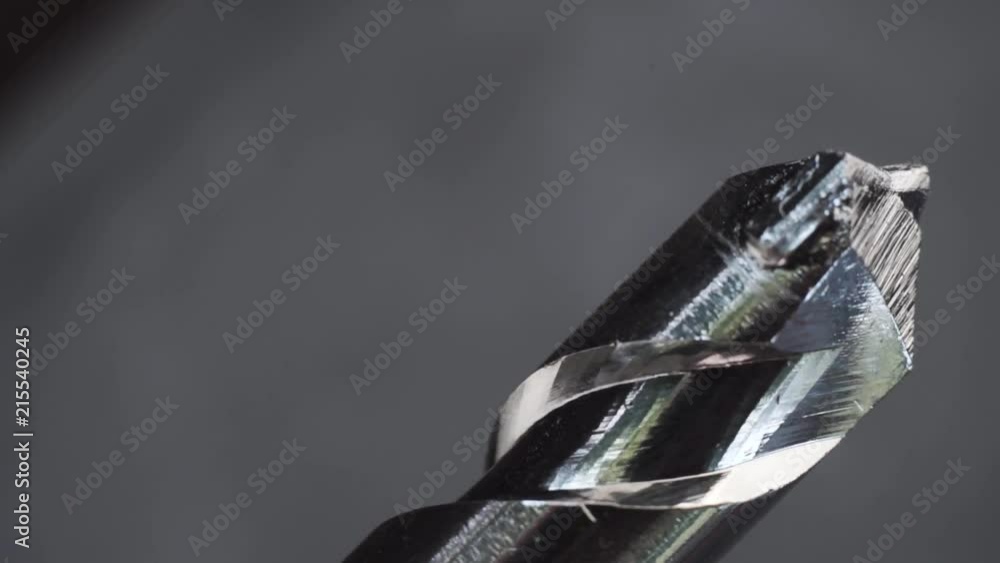 Poster Silver drill bit rotation on a dark background. Macro view.
