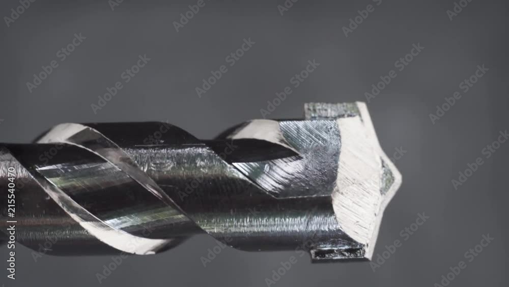 Poster Silver drill bit rotation on a dark background. Macro view.