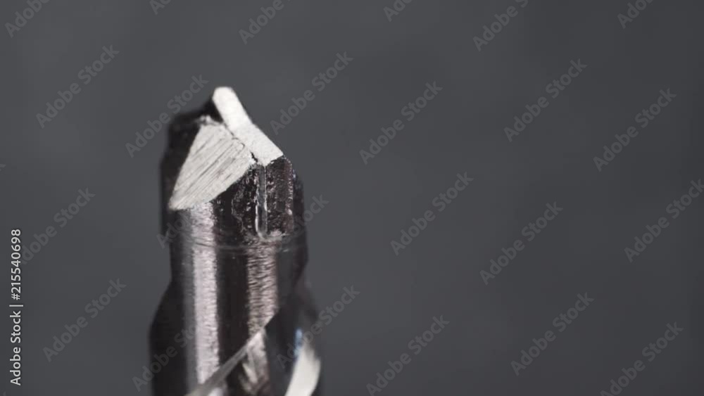 Poster Silver drill bit rotation on a dark background. Macro view.
