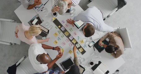 diverse business people marketing team brainstorming ideas on successful financial solution planning strategy using colorful note paper in boardroom meeting top view