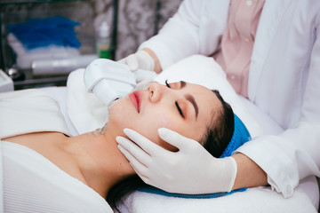 Young Asian woman getting IPL and laser treatment by beautician at beauty clinic.