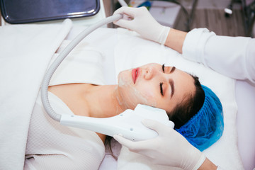 Young Asian woman getting IPL and laser treatment by beautician at beauty clinic.