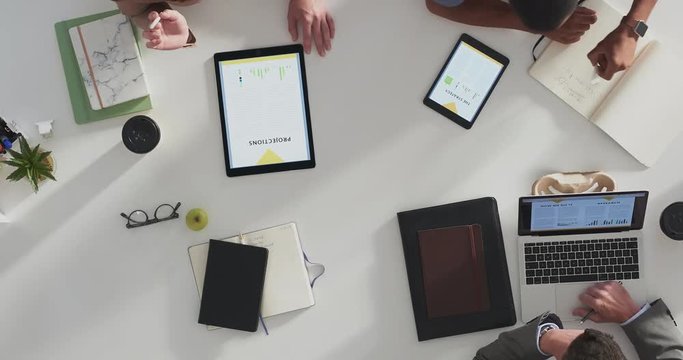 above view young diverse marketing research team brainstorming working on startup business solution viewing graph statistics using tablet laptop technology time lapse close up