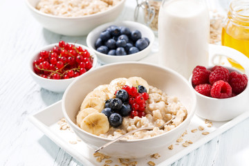 homemade oatmeal with berries for breakfast on white background, closeup