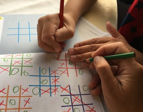 Mum And Kid Playing Tic Tac Toe In Travel