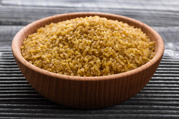 raw bulgur on a rustic wooden background
