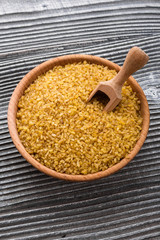 raw bulgur on a rustic wooden background