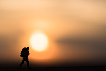 Abstract,silhouette traveler backpacker alone on a sunset background.