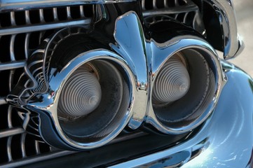 Antique car detail, chrome headlights and grille.  Fifties style.