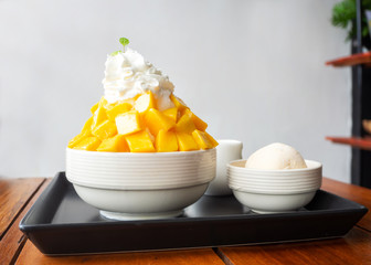 Shaved ice dessert served with mango sliced and whipping cream. Sweet dessert in Korean style....