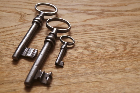 Old metal keys on a wooden background