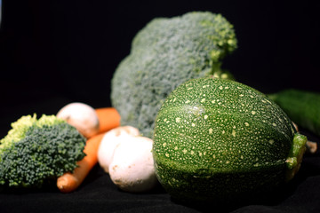 Juicy bright fresh vegetables on a black background on a table
