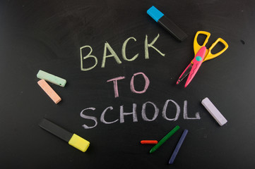 Chalk title on school blackboard near different stationary