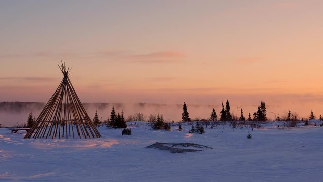 Teepee at dawn by misty northern river in winter, medium