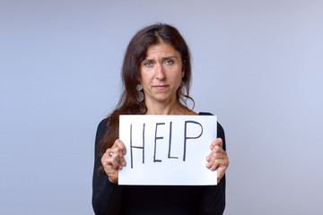 Mature woman holding paper with help lettering