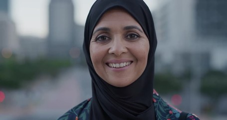 slow motion portrait middle aged muslim woman smiling happy enjoying successful urban lifestyle independent senior female wearing hijab headscarf in city at sunset - Powered by Adobe