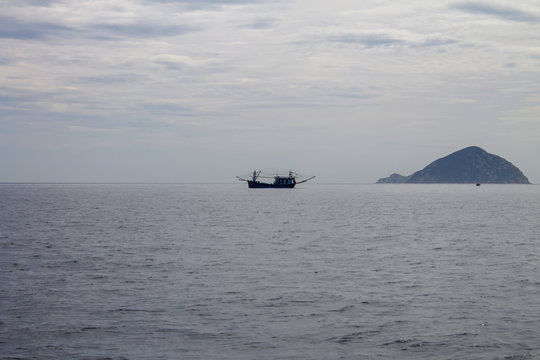 одинокая рыбацкая лодка в туманном море