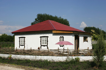 Fototapeta na wymiar Rural house in white with a red iron roof.