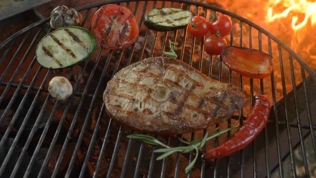 Juicy steak white sea fish grilled and grilled vegetables, cherry tomatoes and zucchini, photo close-up, in the background fire