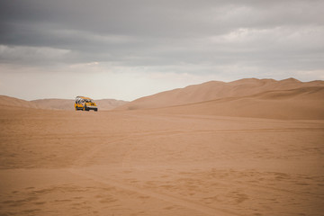 Dune buggy drives across the sand in the Ica desert outside Huacachina, Peru