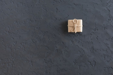 Brown kraft gift box on plaster dark textured table, top view and flat lay