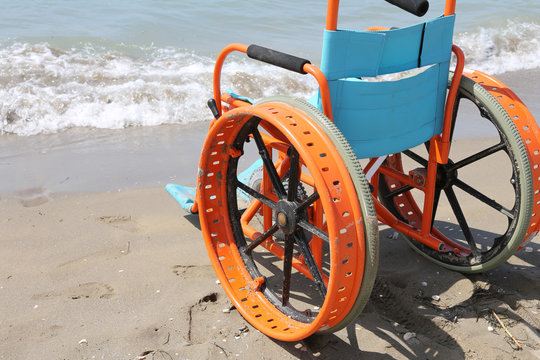 orange wheelchair by the sea used to help disabled people