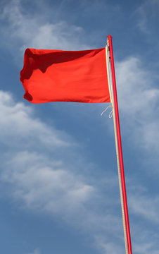 red flag waves and blue sky on background
