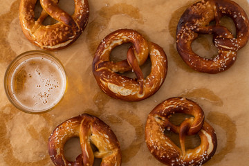 Traditional German Savory Lye Pretzel with Salt on Piece of Parchment Paper. Poster Banner for Bakery. Copy Space.Top View.Toned image.
