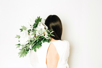Young woman holding white peonies bouquet on white background.