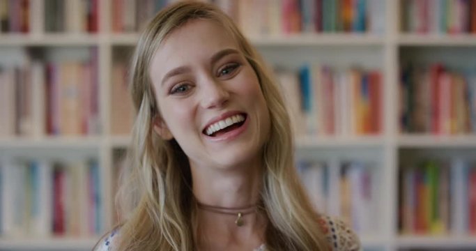 portrait young beautiful blonde woman student laughing enjoying successful lifestyle happy cheerful college girl in bookshelf background slow motion