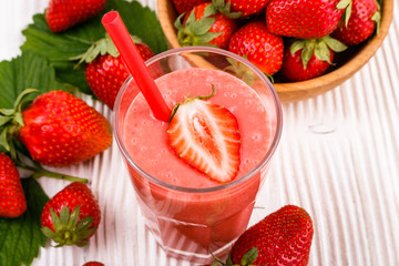 fresh strawberrysmoothie or milkshake on a wooden rustic background