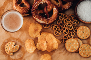 Lager beer and snacks on table. Nuts, chips, pretzel. Top view with copy space