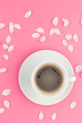 Flat lay of coffee and white flowers petals