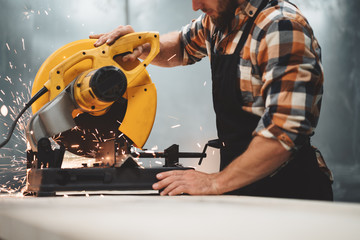Mechanic angular grinding machine in action, sparks fly apart. Work in process on metalworking...