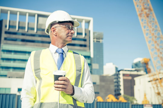 Engineer builder on construction site at sunny day with coffee i