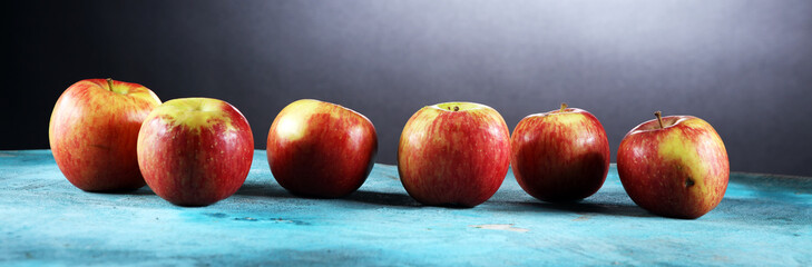 Fototapeta na wymiar Ripe red apples with leaves on wooden background.