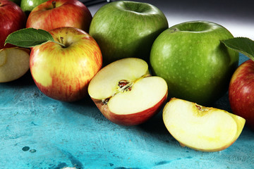 Ripe red apples with leaves on wooden background.