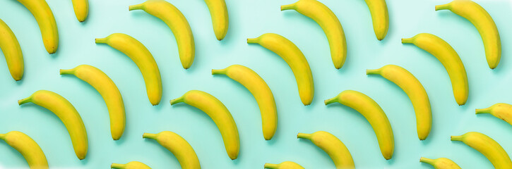 Geometric colorful fruit pattern. Bananas over blue background. Banner. Top view. Pop art design, creative summer concept. Minimal flat lay style.