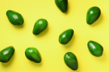 Avocado pattern on yellow background. Top view. Banner. Pop art design, creative summer food concept. Green avocadoes, minimal flat lay style.