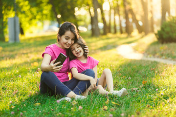 Young mother with pretty daughter make photo in park