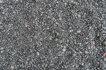 Textura e padrão criados por pequenas pedras de basalto, numa praia de areia preta na Islândia