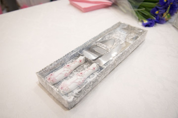 Cutlery for cutting a cake in a vintage packing on a white table.