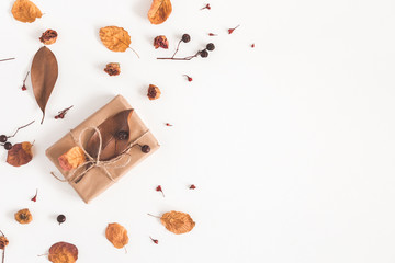 Autumn composition. Gift box, dried flowers and leaves on white background. Autumn, fall concept. Flat lay, top view, copy space